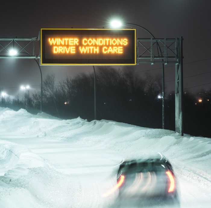 image of a car driving in terrible snow storm